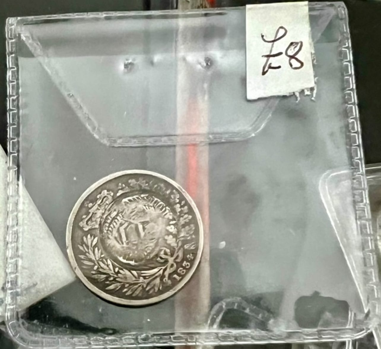 قطعة Sixpence من 1834 داخل ألبوم عملات مع علامة £8